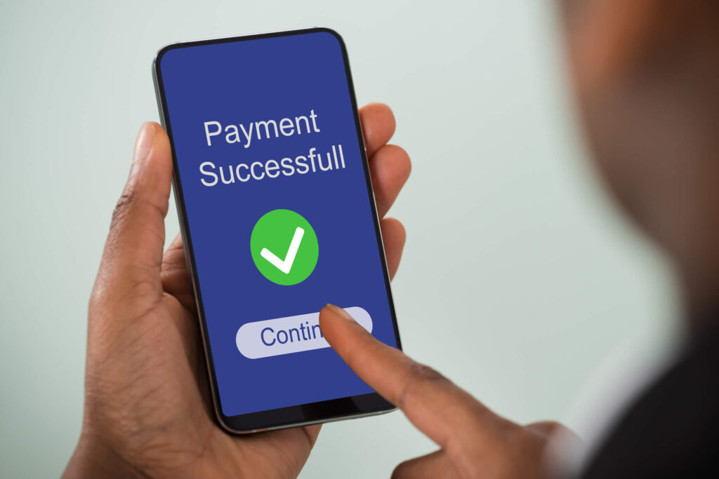 Learn how online payment options for rent will help your tenants and increase your profits. Tenant paying their rent on their mobile phone.