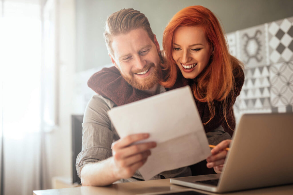 Happy rental property owners looking at their financial statements after working with a property manager.