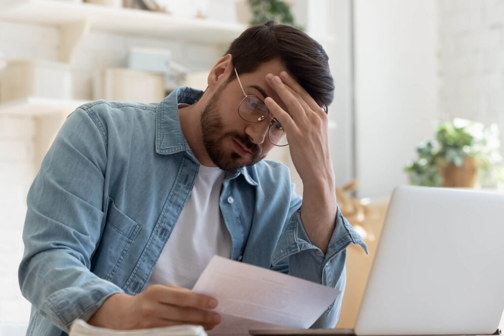 A Howard County, Maryland, rental property owner looking at paperwork stressed out over financial performance of their investment.